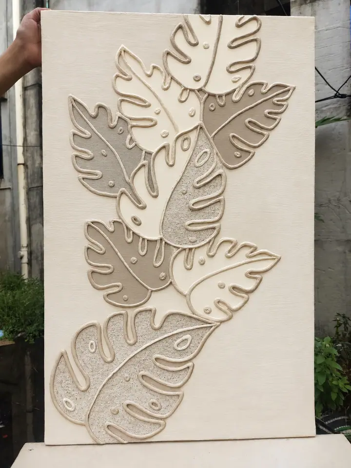 Cream relief artwork of overlapping monstera leaves in beige, taupe and sand textures